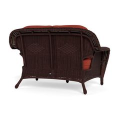 a brown wicker couch with red cushions