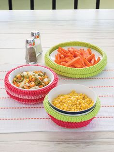 three bowls filled with food sitting on top of a table