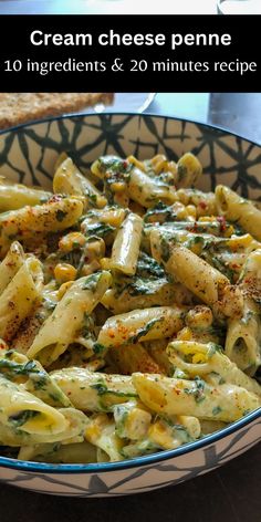 a bowl filled with pasta covered in cheese and spinach sauce on top of a table