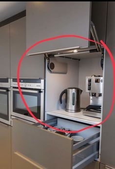 a kitchen with stainless steel appliances and an open drawer in front of the stove top