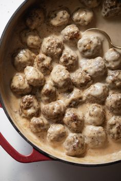 meatballs and gravy are being cooked in a pot