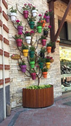 a tree made out of potted plants on the side of a building