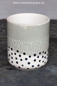 a white and black polka dot cup sitting on top of a table