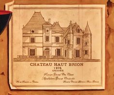 a wooden plaque with a drawing of a house on it's side and the name chateau haut brion