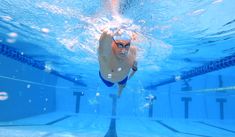 a man swimming underwater in a pool