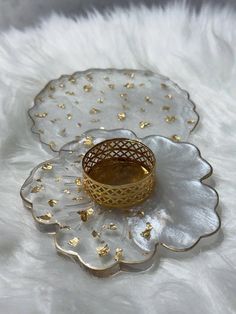 a white and gold plate with a ring on it sitting on a furnishing