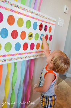 a little boy that is standing in front of a wall with some decorations on it