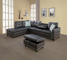 a black leather sectional sofa sitting on top of a wooden floor next to a footstool