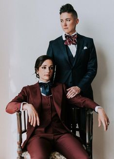 a man in a tuxedo sitting next to a woman wearing a red suit