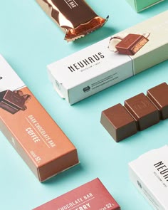 several different types of chocolate bars on a blue surface with one bar in the middle