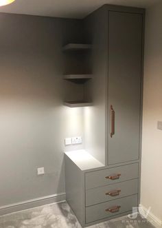 an empty room with two drawers and a cabinet in the corner that is painted gray