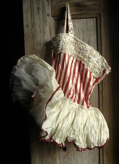 an old fashioned dress hanging on a wooden door