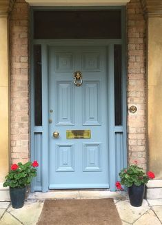 a blue front door with two flower pots