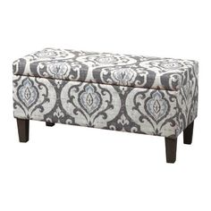 a large ottoman with a blue and white pattern on the top, in front of a white background