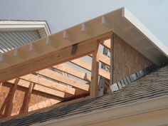 the roof of a house being built with wooden beams and shingles on top of it