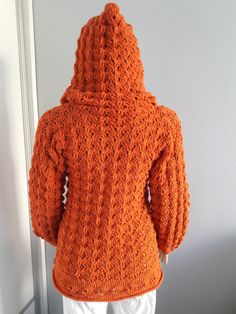 an orange crocheted jacket is shown on a mannequin's head