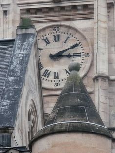 an old building with a large clock on it's face and two spires