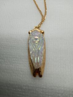 VERY unusual carved AB coated clear crystal Cicada edged in gold. It's wings are folded on the top side and when you turn it over you see the bottom side.  24" gold chain; Cicada is 2 1/4" long and 3/4" wide. For many people the cicada has special meaning..personal change, renewal,rebirth and transformation. The Cicada inherently symbolizes what they were (nymph) and all the glory of what they have become (adult form).  The AB coating on 1/2 of the carved crystal stands for Aurora Borealis and when the light hits the carving it has a beautiful shimmery ethereal look.  This item is lead and nickel free and hypoallergenic. It will arrive in a gift box with a jewelry cloth and care instructions. Etched Gold Metal Jewelry, The Glory, Aurora Borealis, Clear Crystal, Gold Pendant, Gold Chain, Gold Chains, Favorite Jewelry, Jewelry Necklace Pendant