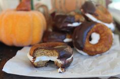 chocolate covered doughnuts with marshmallows and pumpkins in the background