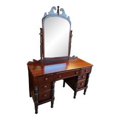 an antique wooden dressing table with mirror on it's top and drawer drawers underneath