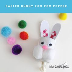 an easter bunny made out of toilet paper with pom poms on the side