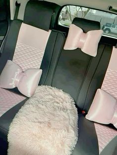 the interior of a car with pink and black bows on the front seat, and a dog bed in the back