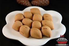 a white plate filled with cookies on top of a black table next to chocolates