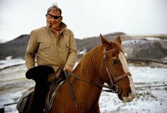 a man riding on the back of a brown horse