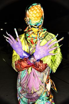 a person with painted hands and colorful clothing