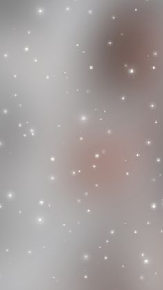 blurry image of small white stars in the sky with pink and gray hues