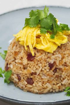 rice with eggs and cilantro on top in a blue plate, ready to be eaten