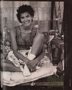 a black and white photo of a woman sitting on a bed