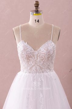 a white wedding dress on a mannequin with lace and tulle overlay