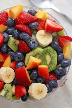 a glass bowl filled with fruit on top of a table