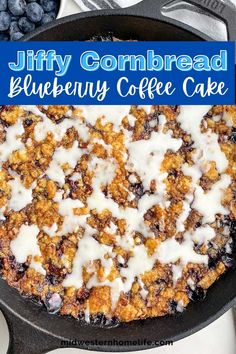 a blueberry coffee cake in a cast iron skillet with white icing on top