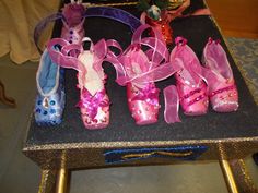 several pairs of pink and blue ballet shoes are sitting on a black table with gold legs