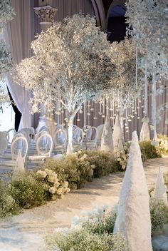 an elaborate wedding setup with white trees and chairs