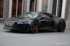 a black sports car parked in front of a building