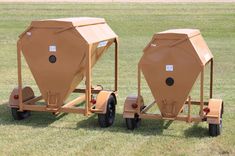 two large brown tanks sitting on top of a trailer in the middle of a field