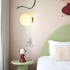 a bedroom with pink walls and green headboard, white bedding, and an animal figurine on the night stand