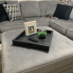 a living room with a gray couch and black tray on the coffee table in front of it