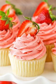 cupcakes with pink frosting and strawberries on top