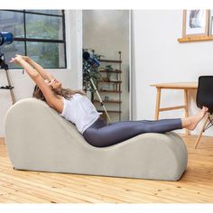 a woman sitting on a bean bag chair in a living room with her legs up