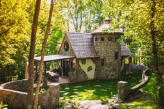 a small stone house in the woods surrounded by trees