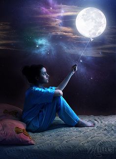 a person sitting on a bed holding a string in front of the moon and stars