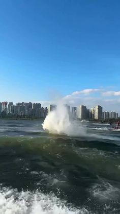 a jet ski being pulled by a boat on the water with buildings in the background