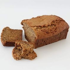 a loaf of bread sitting on top of a white table next to two pieces of bread