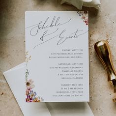 the wedding stationery is laid out on top of some papers and a gold object