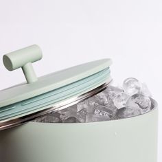 an ice bucket filled with lots of ice next to a canister full of ice