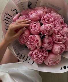 a woman holding a bouquet of pink flowers